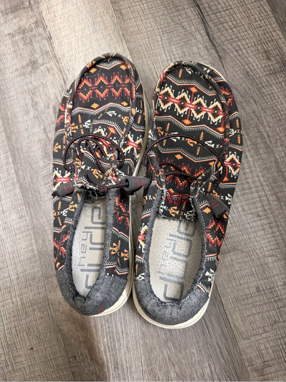 Hey Dude mens Slip-On Sneakers in Black with Red & Tan Aztec Print